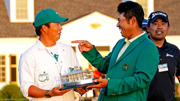 Hideki Matsuyama celebrates with his caddie Shota Hayafuji and The Master trophy.